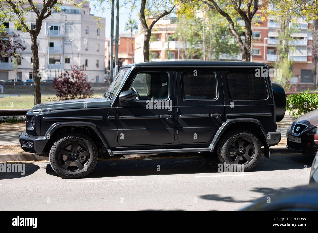 Mercedes Benz G-Class parked in series on the street. It is a modern and powerful German luxury SUV on the city street among other cars. Stock Photo