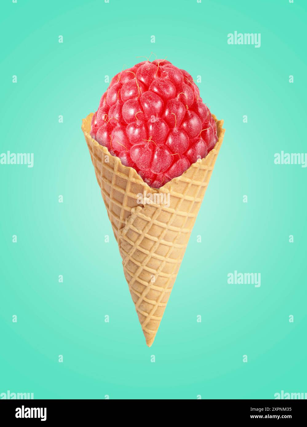 Ice cream cone with raspberry on turquoise background Stock Photo - Alamy