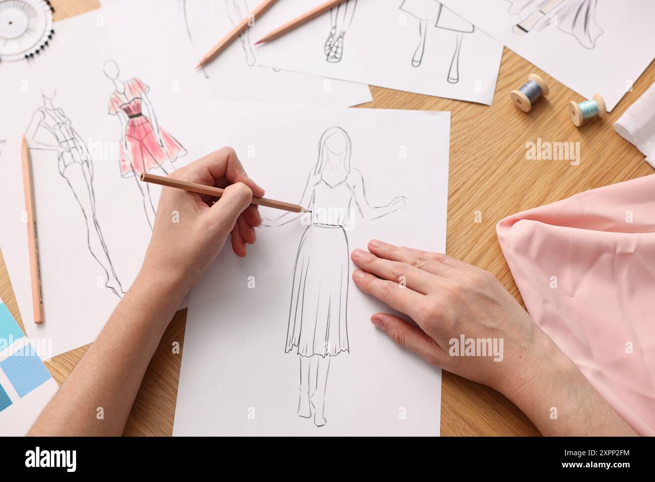 Fashion designer drawing sketch of beautiful dress at wooden table, top  view Stock Photo - Alamy