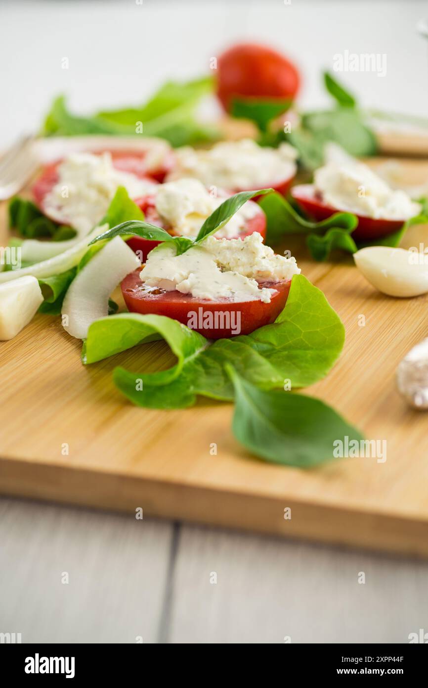 tomato wedges with cottage cheese filling and garlic, spicy appetizer . Stock Photo