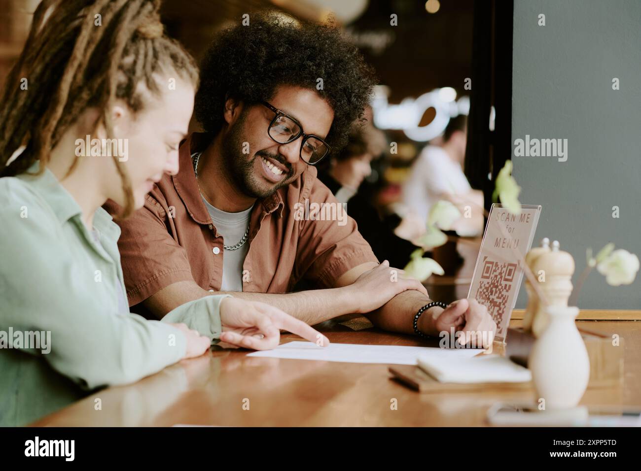 Discussing Menu Options in Modern Cozy Cafe Stock Photo - Alamy