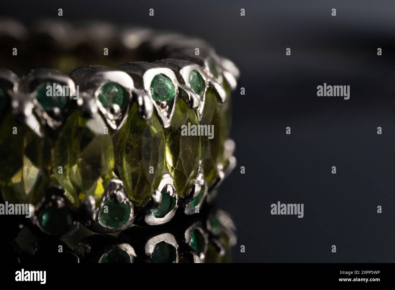 silver ring with emeralds and peridots on background Stock Photo
