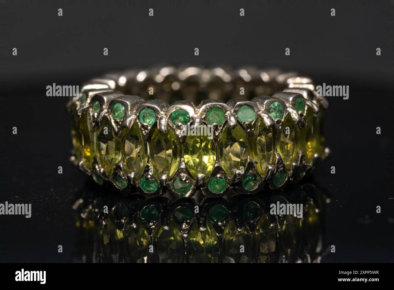 silver ring with emeralds and peridots on background Stock Photo