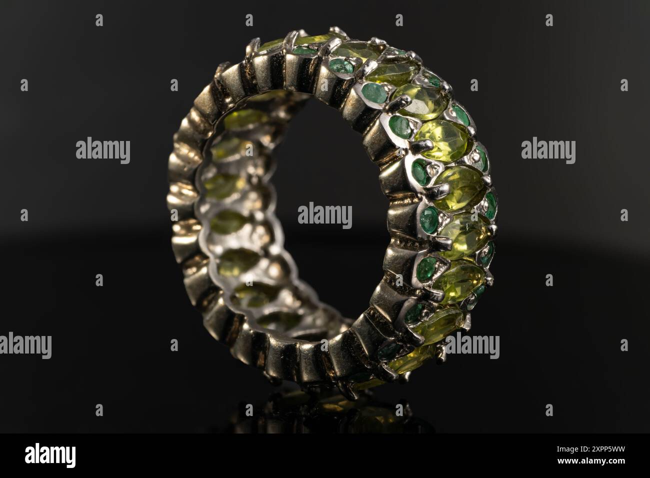 silver ring with emeralds and peridots on background Stock Photo