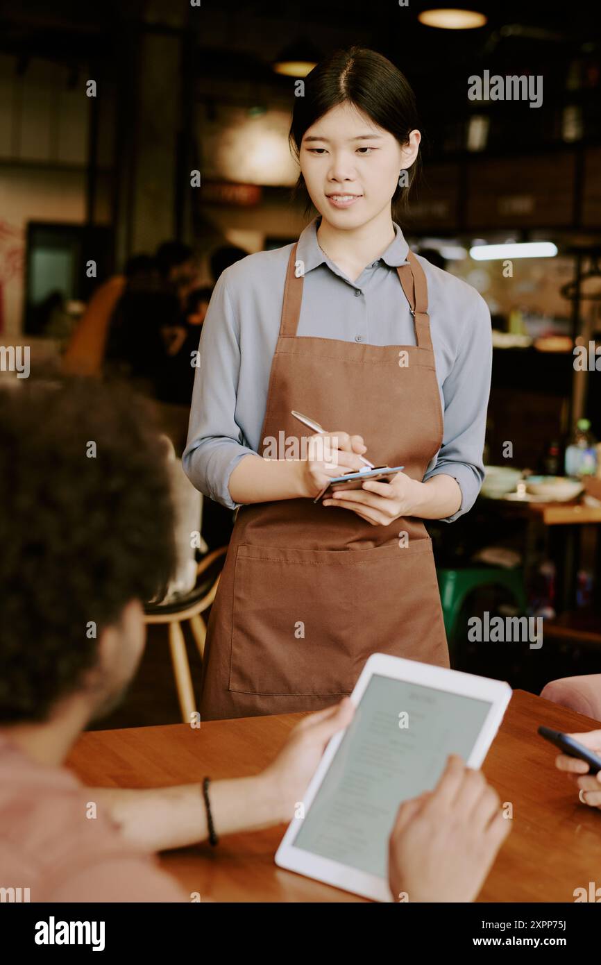 Waitress Taking Order from Customer in Cozy Restaurant Stock Photo