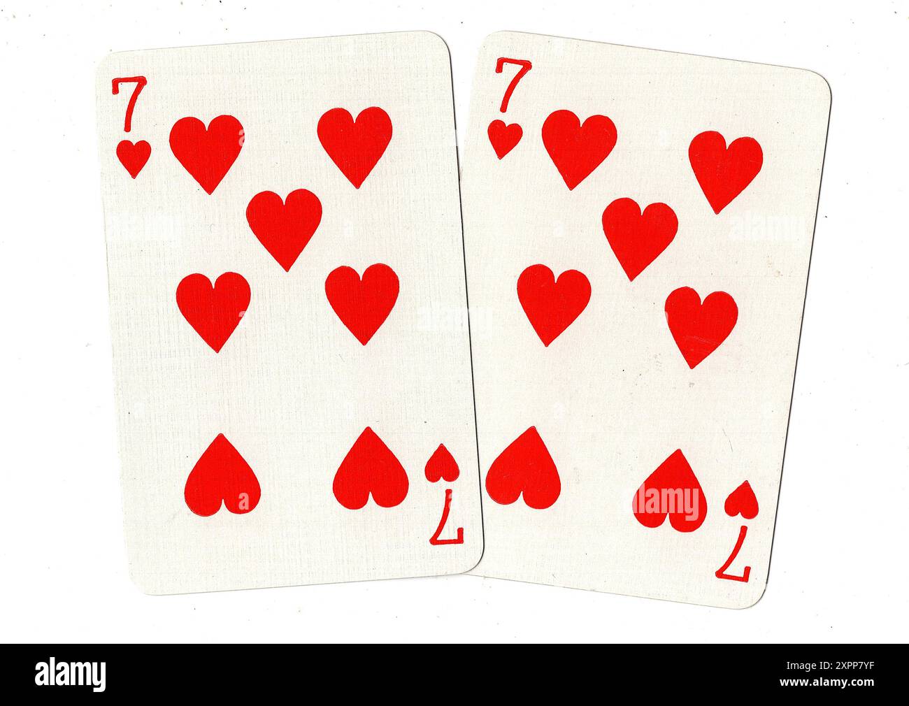 A pair of vintage seven of hearts playing cards on a white background ...