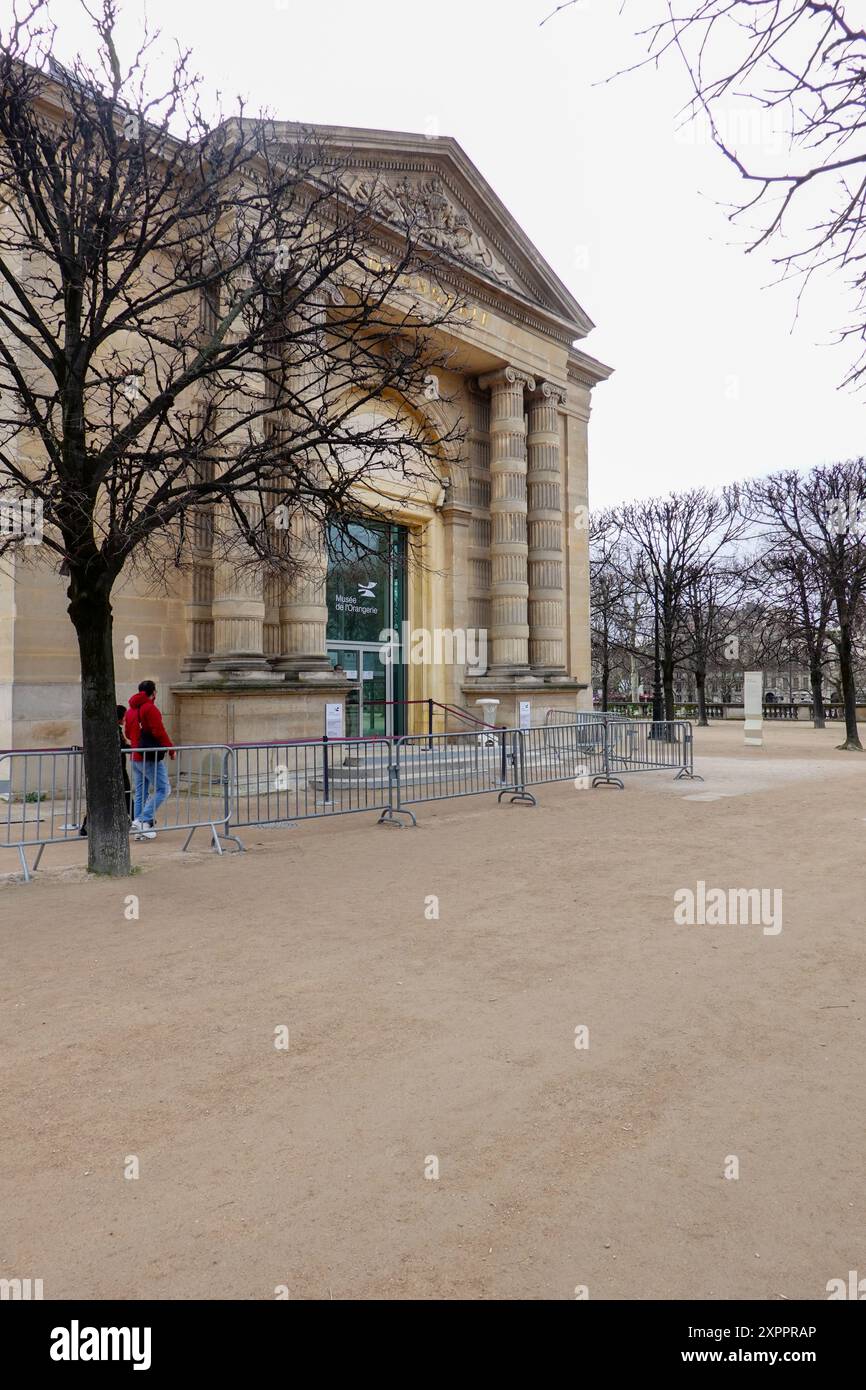 Two people walking towards the entrance of the Musée de l’Orangerie, art gallery of impressionist and post-impressionist paintings, Paris, France. Stock Photo