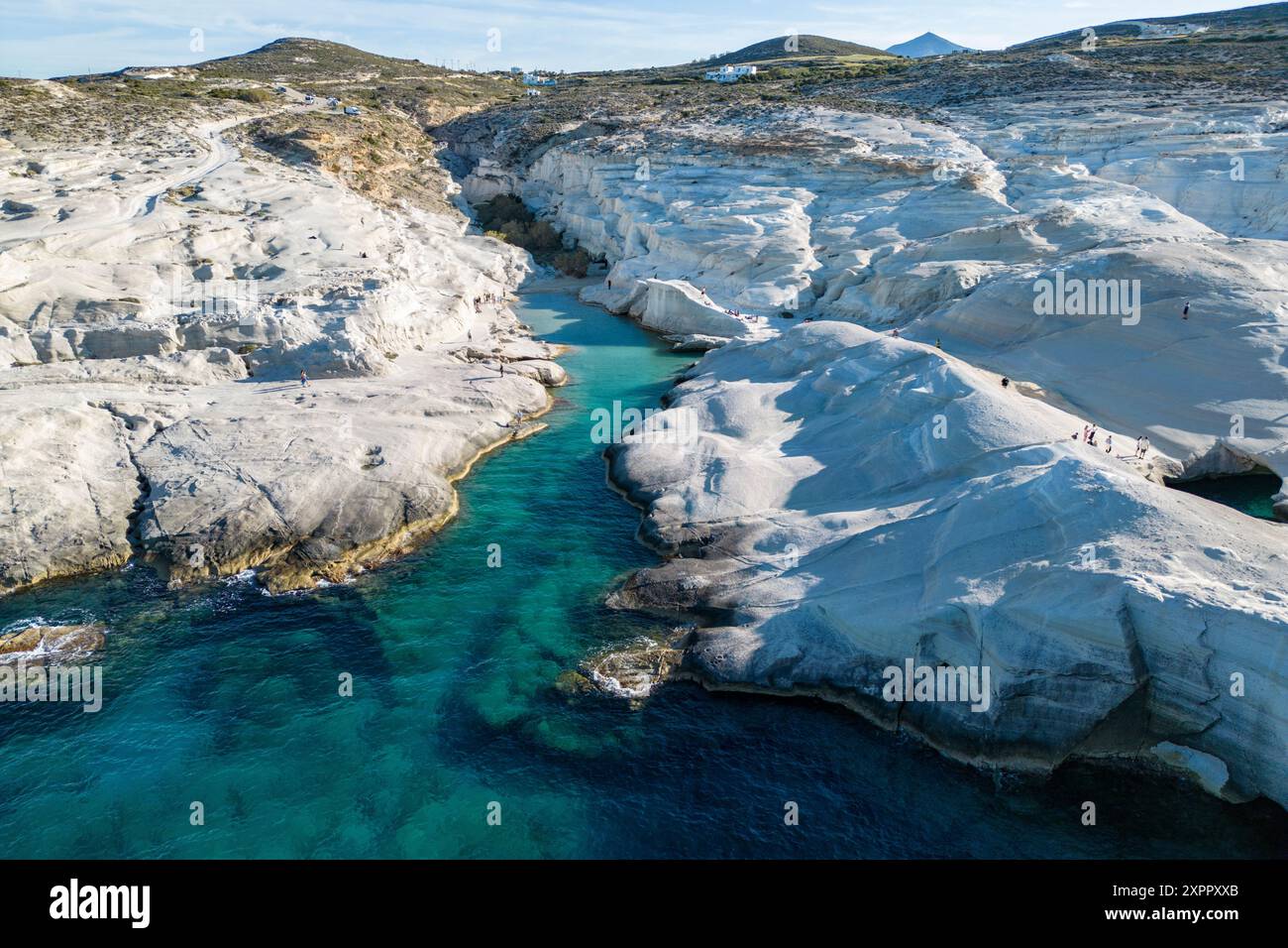 Aerial View Of People At Sarakiniko Beach With Its Grey white Volcanic aerial-view-of-people-at-sarakiniko-beach-with-its-grey-white-volcanic