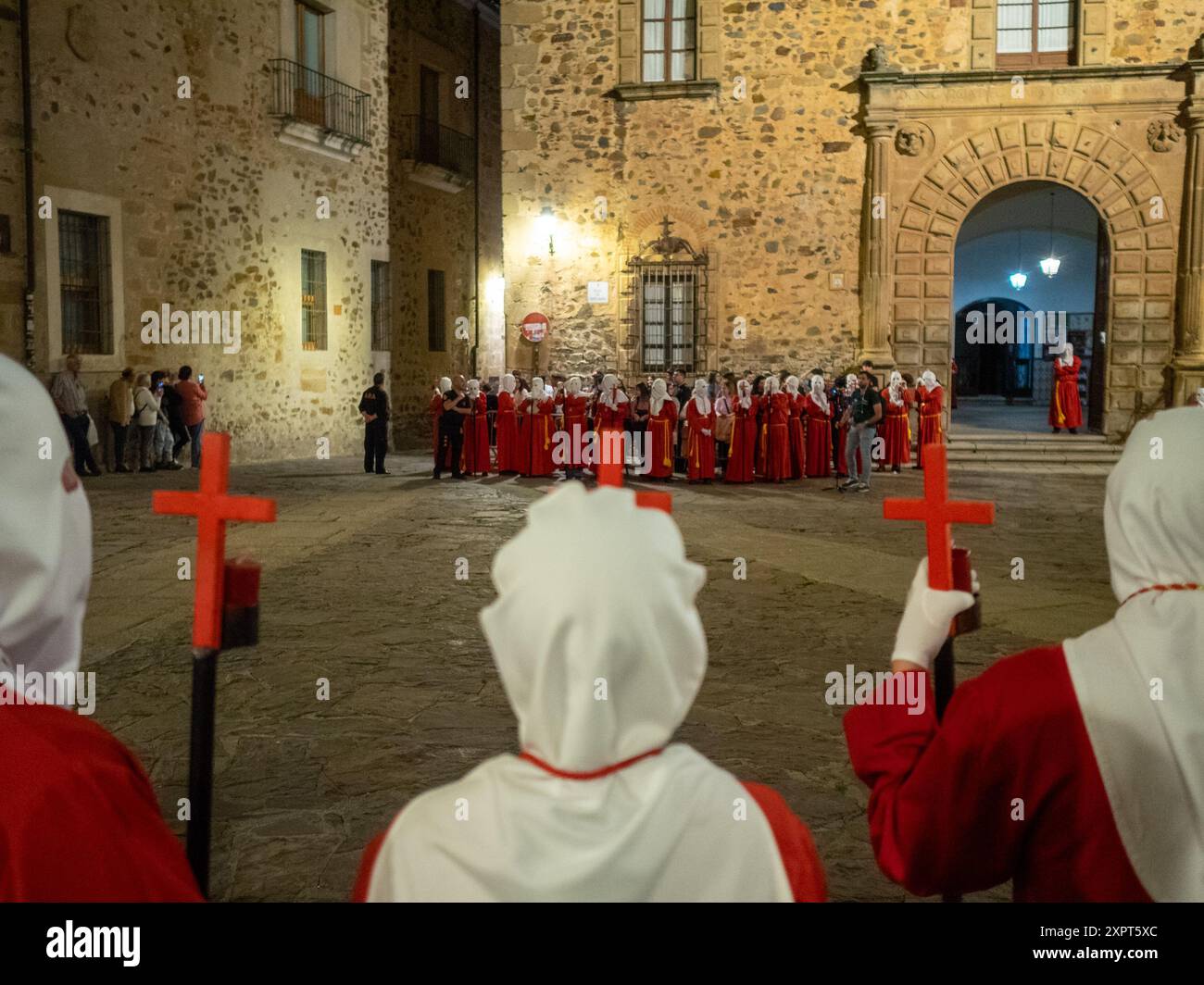 Red and white hooded costumes Good End Procession at night in Caceres Holy Week Stock Photo