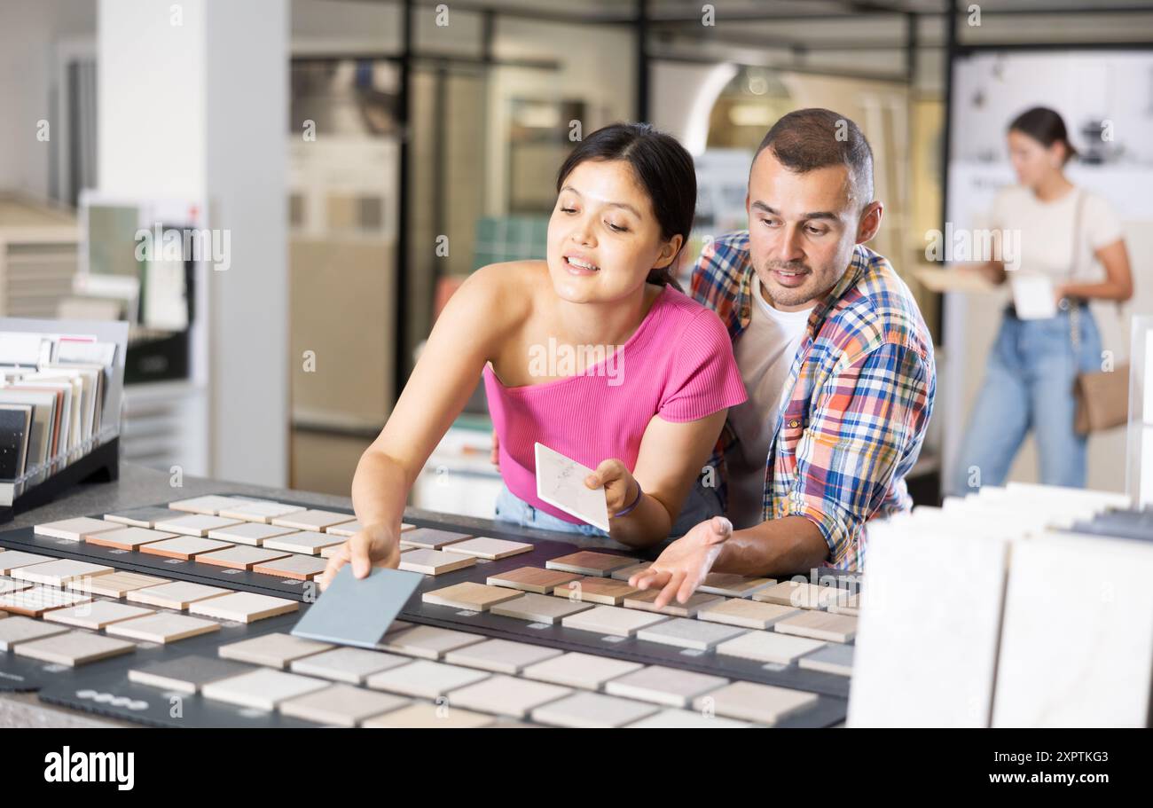 Couple browsing tile samples on display board in home improvement store Stock Photo