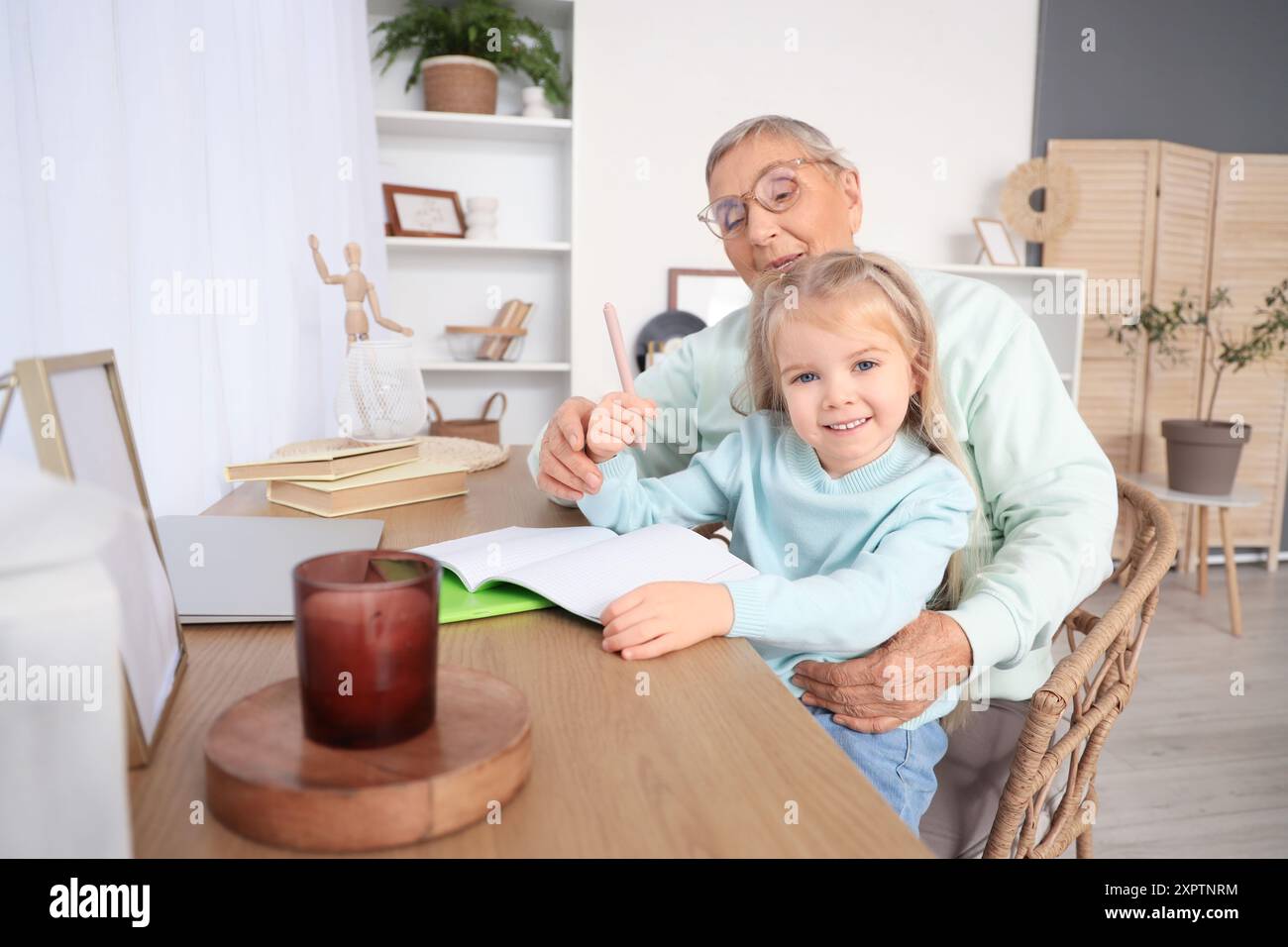 Cute little girl with her granny studying at home Stock Photo - Alamy