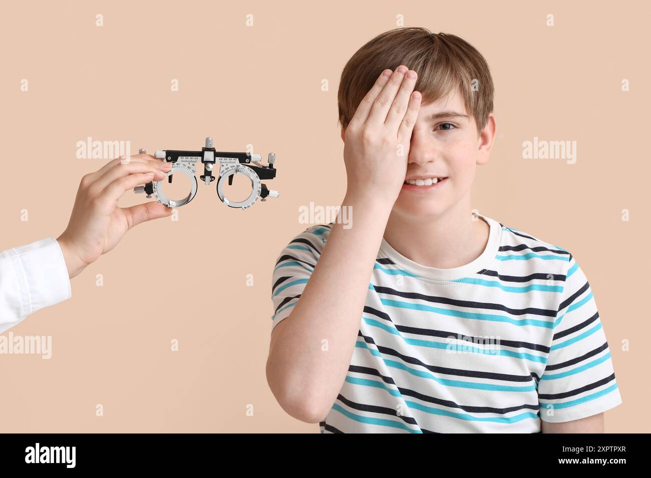 Eye Testing Boy Female ophthalmologist giving trial optical frame to little boy ...