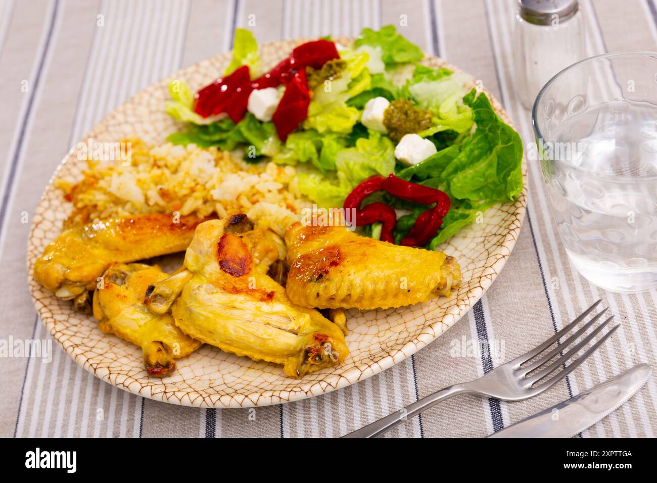 Baked chicken wings with rice and salad Stock Photo - Alamy