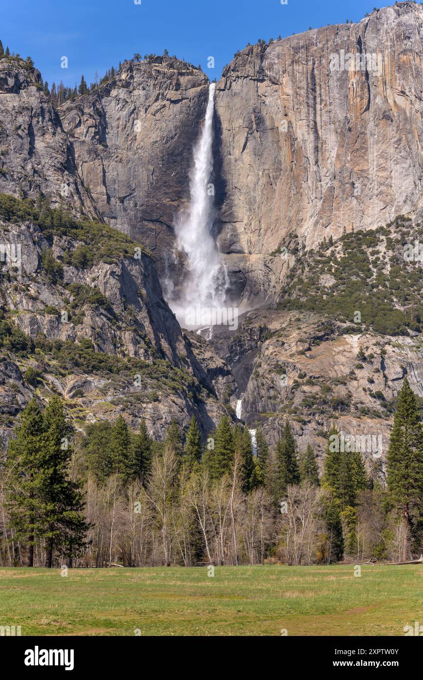 Yosemite Falls - A vertical full view of spectacular Yosemite Falls roaring off steep and solid granite cliff wall on a sunny Spring day. CA, USA. Stock Photo