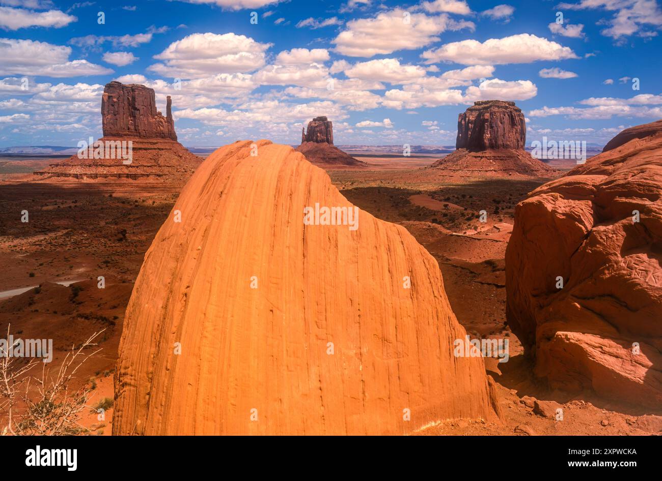 Dappled sunlight paints the view of The Mittens and Merrick Butte at Monument Valley along the Arizona/Utah state line. (USA) Stock Photo