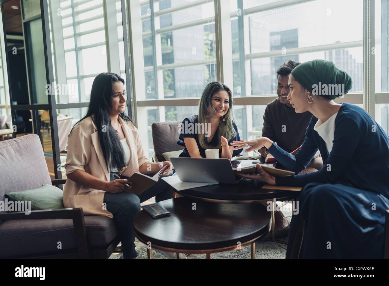 Diverse Asian business executives including a disabled man in wheelchair having a casual meeting Stock Photo