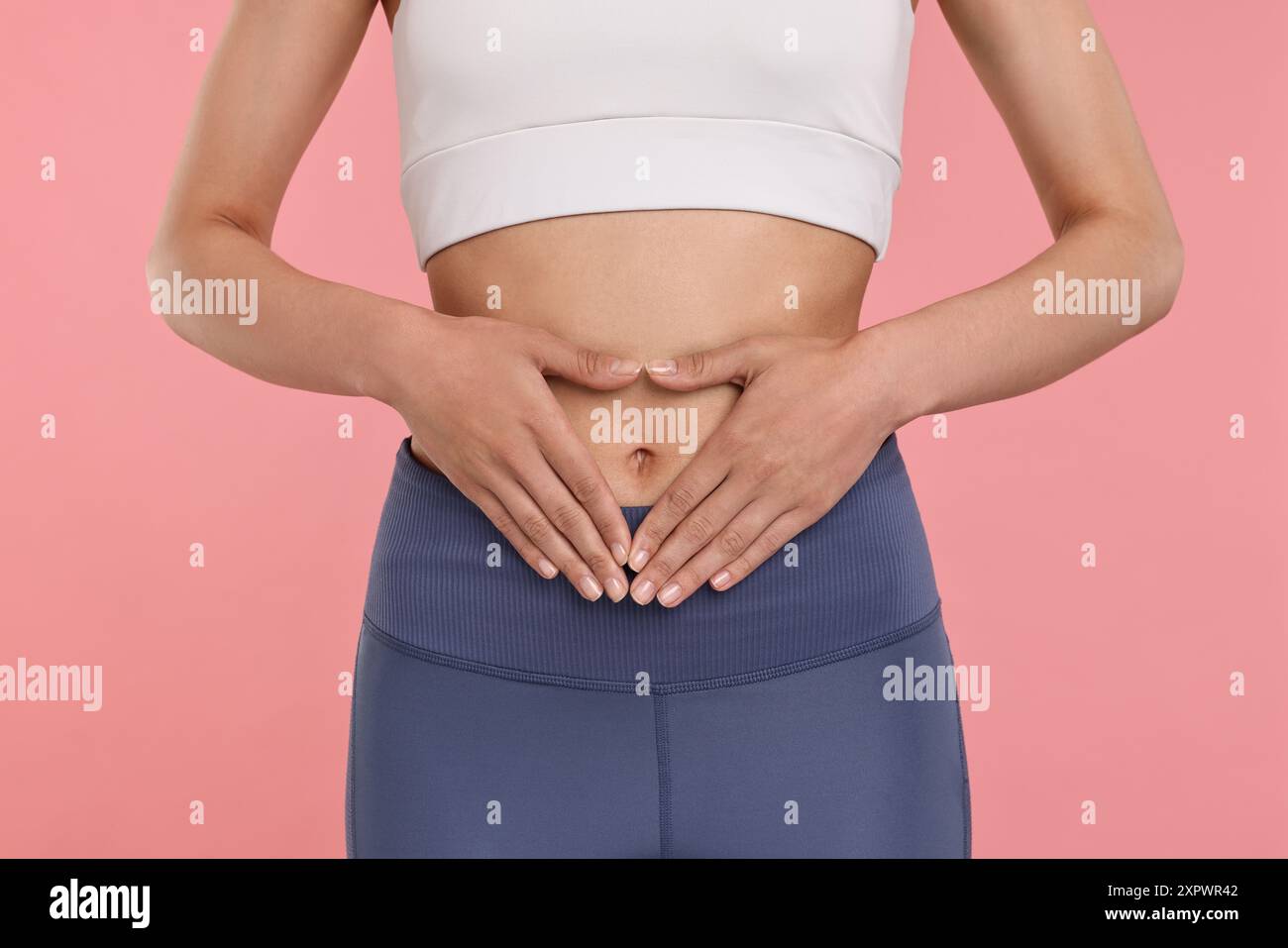 Healthy digestion. Woman making heart shape with hands near her belly ...