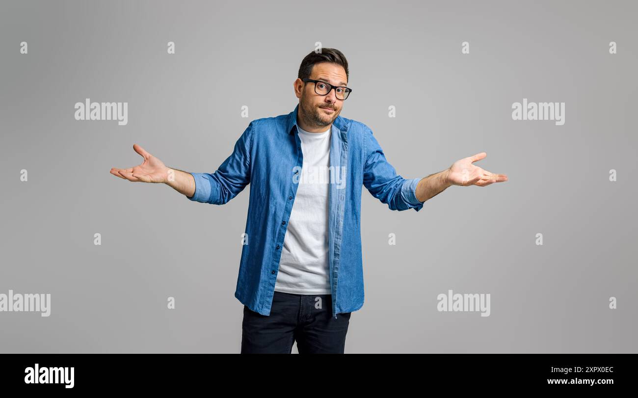 Confused businessman shrugging with raised arms hi-res stock ...