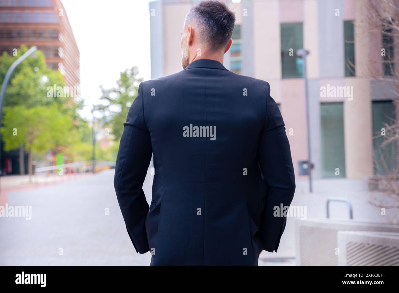 Rear view businessman walking outdoors. Stock Photo