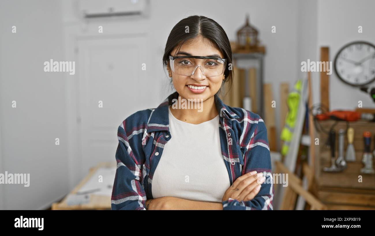 A young indian woman with long hair and safety glasses smiles ...