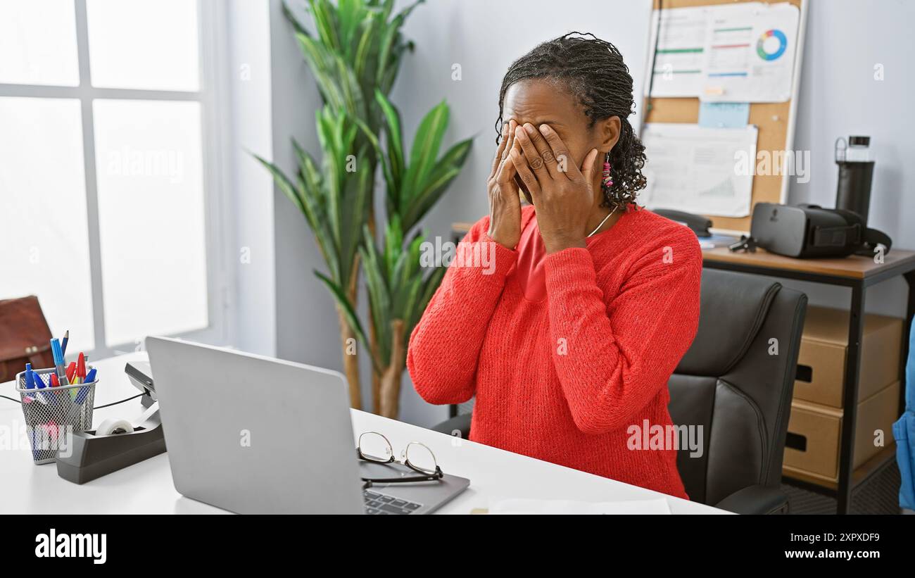 Stressed african american woman in office covering face with hands ...