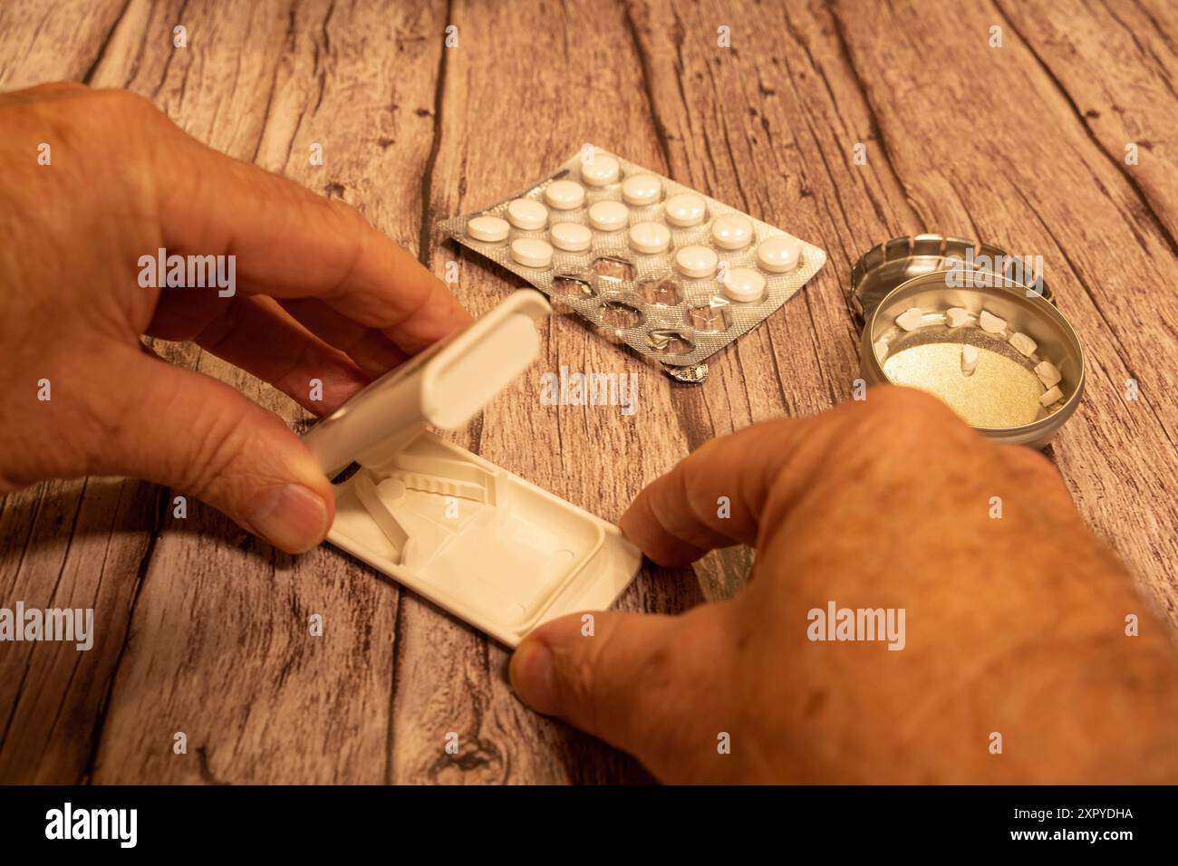 Man divides tablets with tablet divider Stock Photo - Alamy