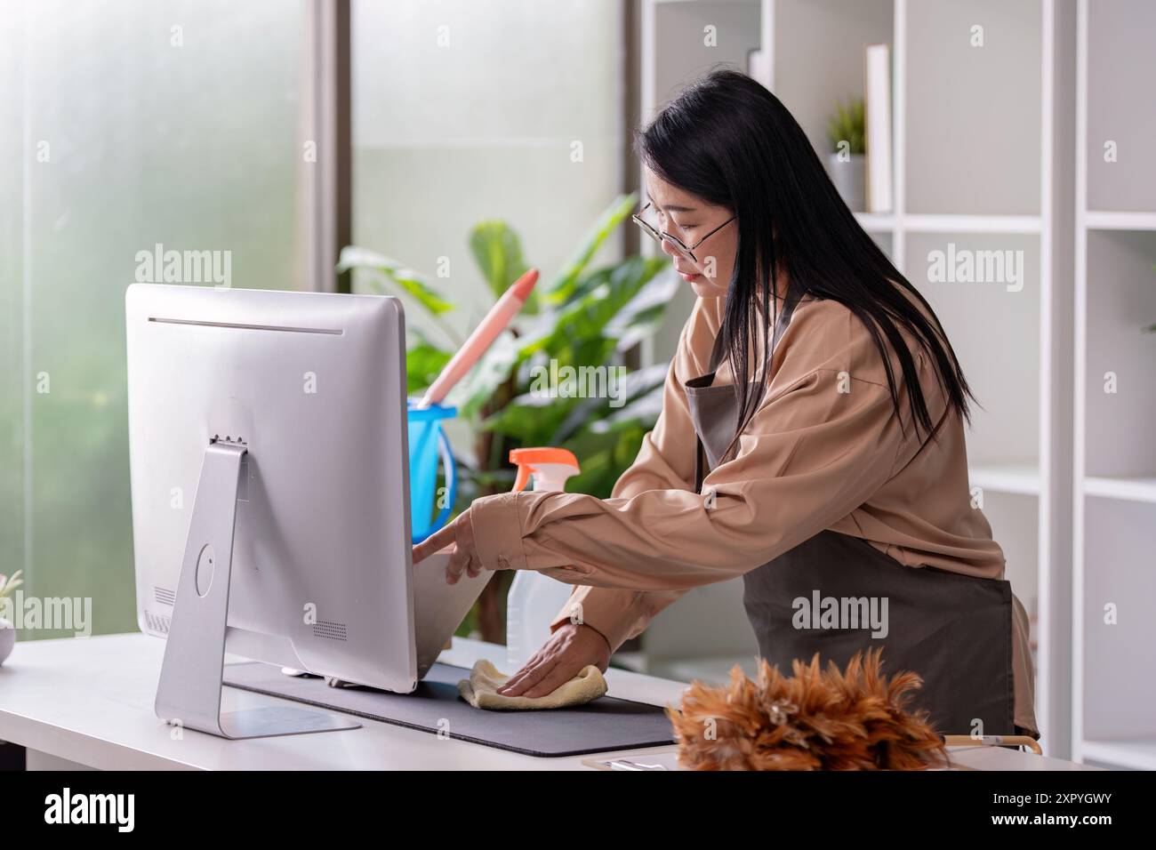 Professional Maid Housekeeper Cleaning Office Desk with Computer and ...