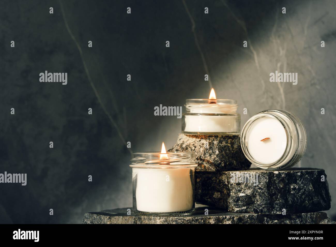 Burning Candles On Rustic Stone Slabs close up Stock Photo