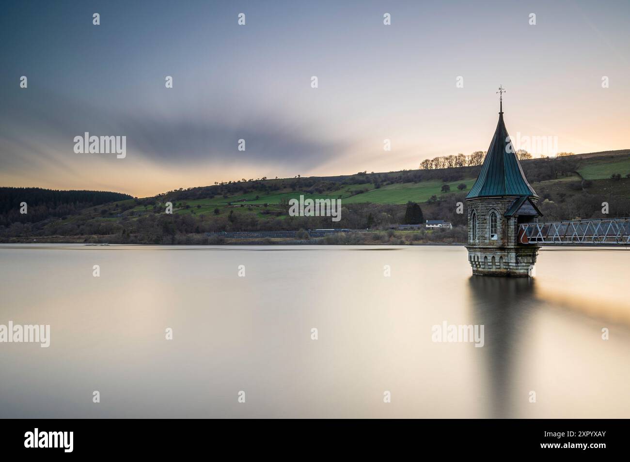 Pontsticill Reservoir on a calm summers morning. A long shutter speed has been used to turn the waters surface into a mirror Stock Photo