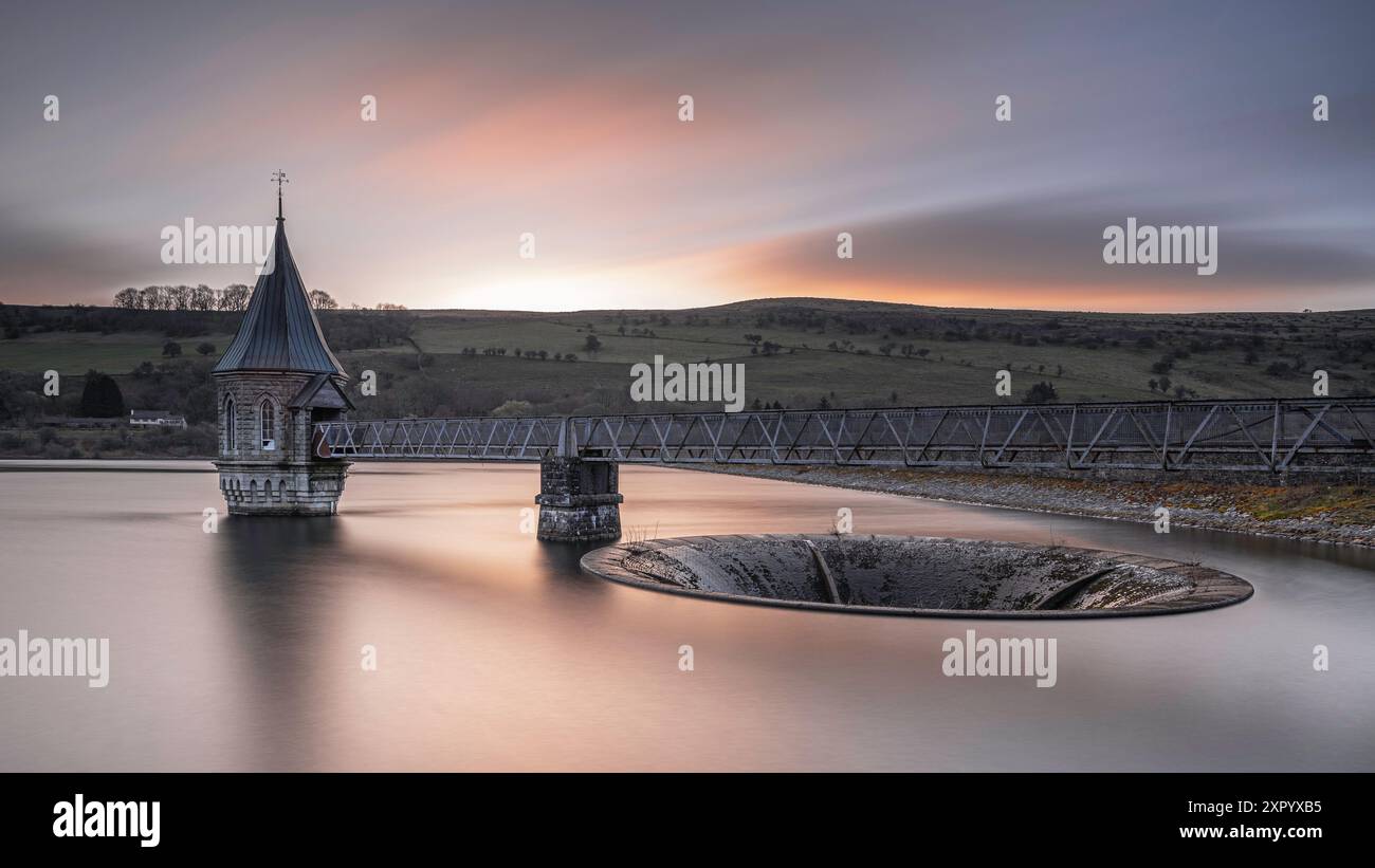 Pontsticill Reservoir on a calm summers morning. A long shutter speed has been used to turn the waters surface into a mirror Stock Photo