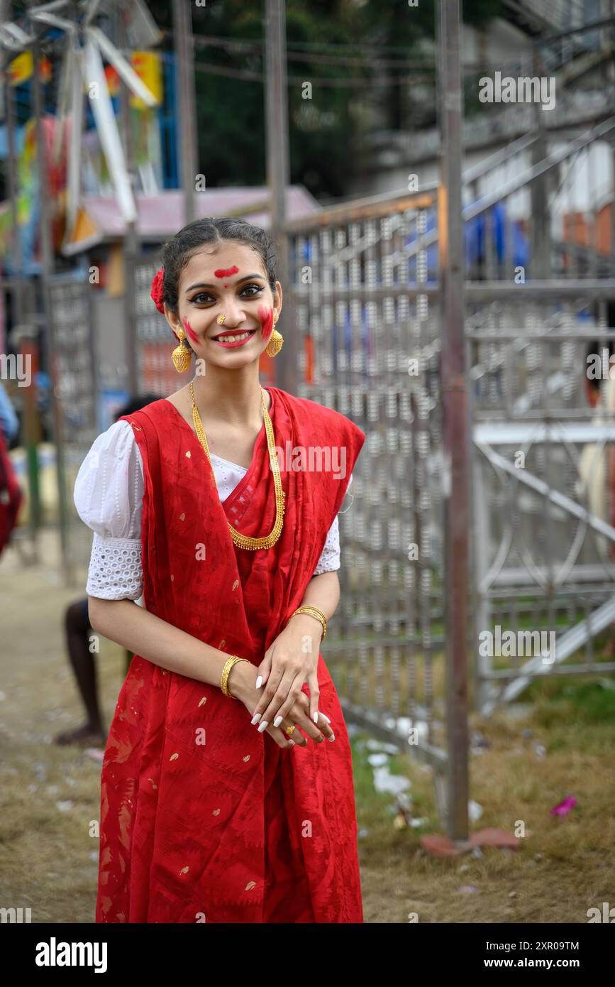 Portrait of beautiful young woman wearing a traditional Bengali festive attire and participating in Sindur Khela at a puja pandal during last day of D Stock Photo