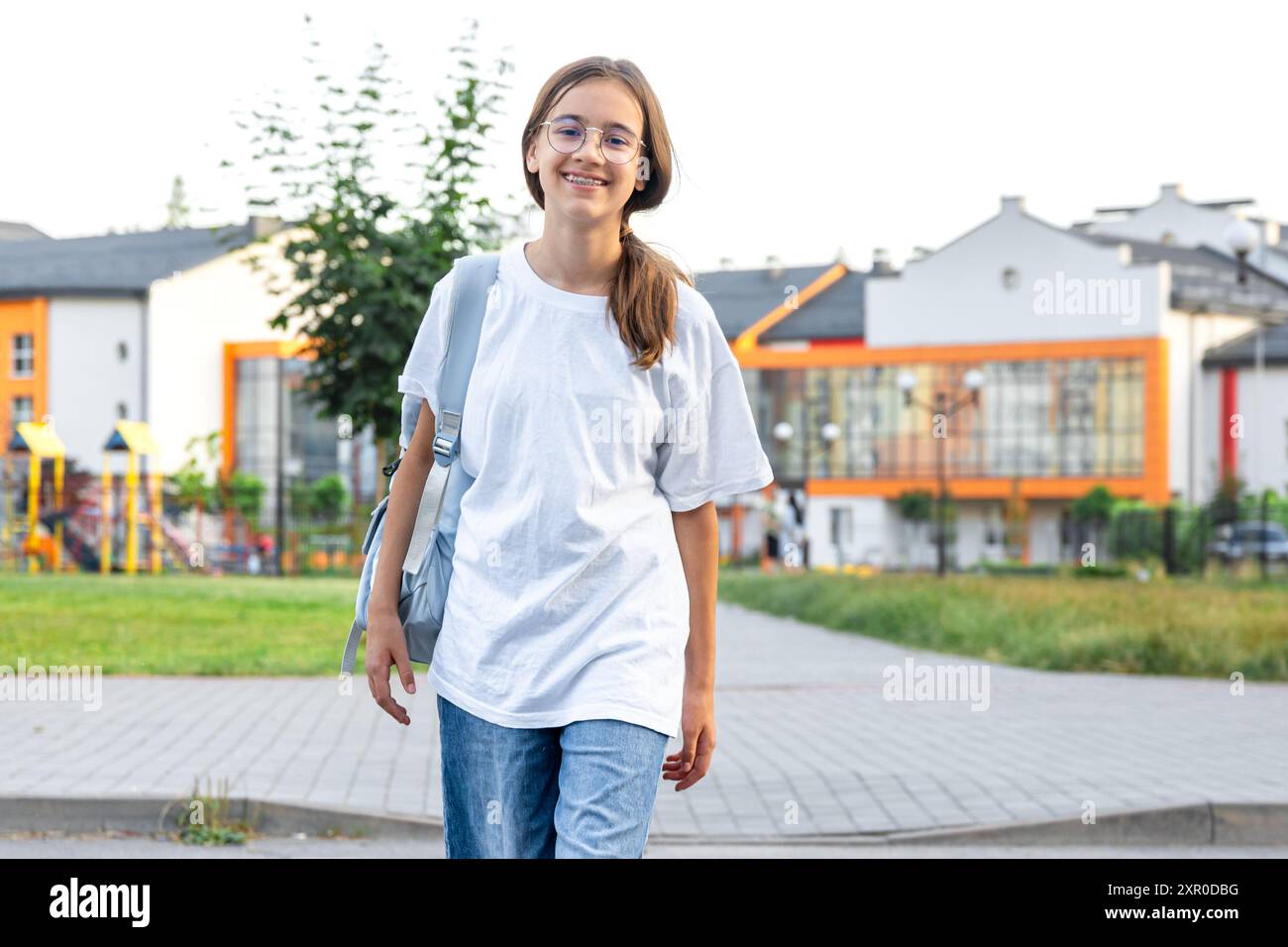 The girl goes to school. A schoolgirl crosses a pedestrian crossing ...