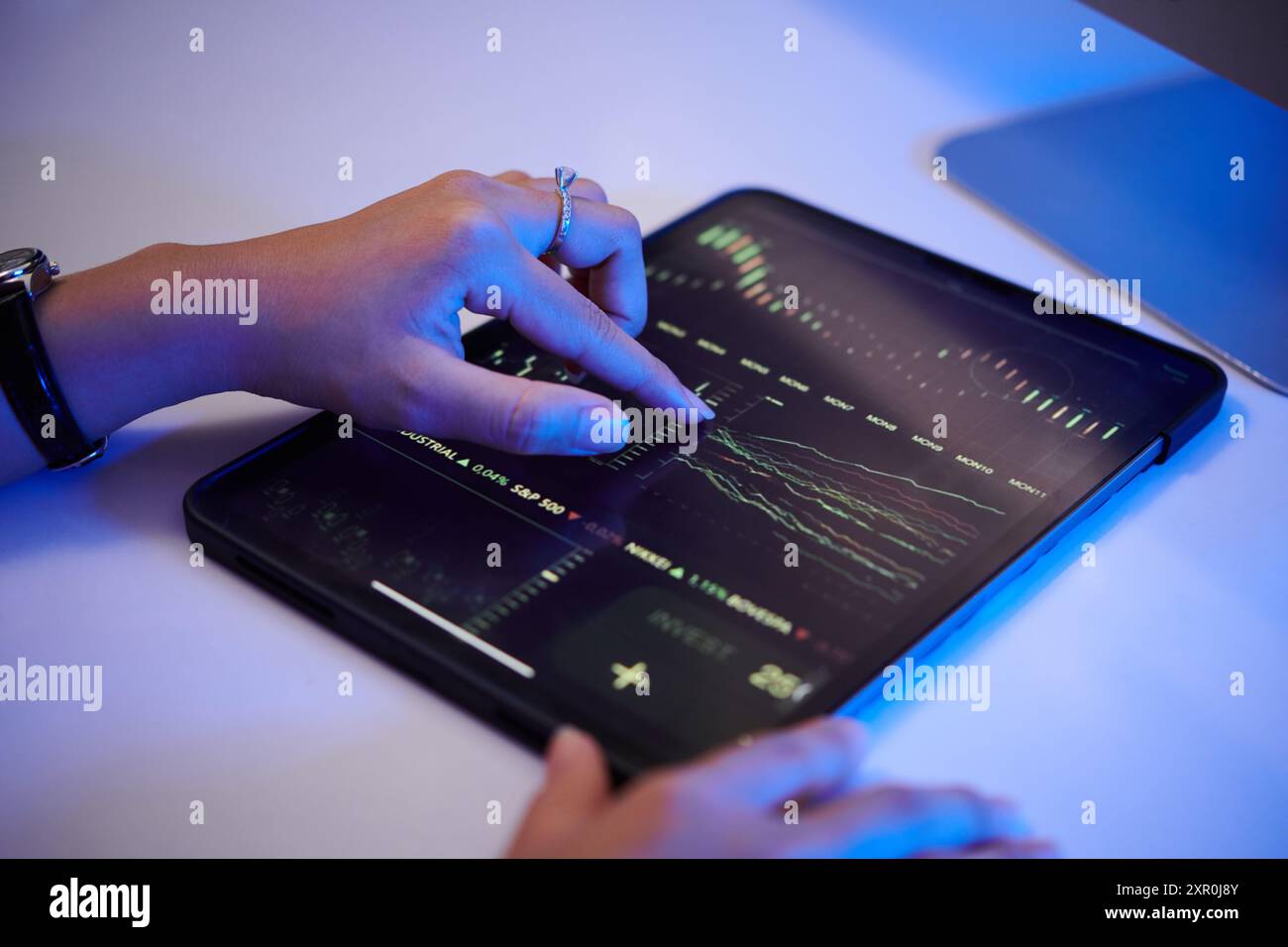 Analyzing Financial Data Using Tablet with Interactive Graphs Stock Photo