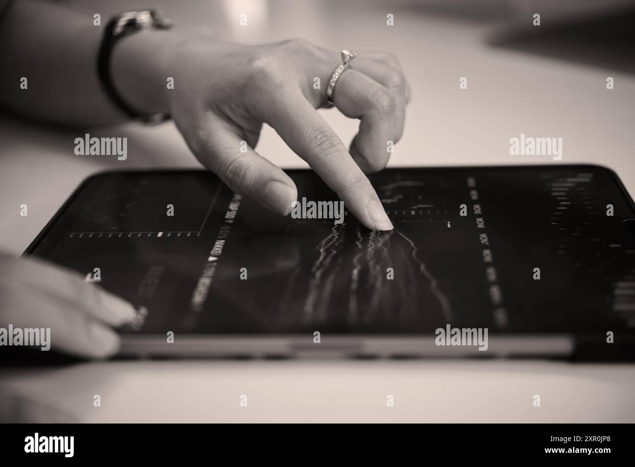 Analyzing Financial Data Using Tablet on Desk Stock Photo