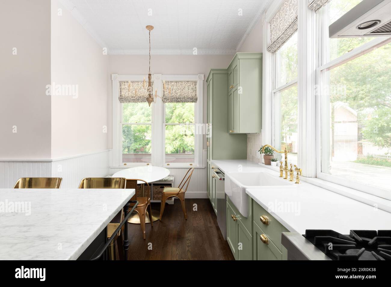 A kitchen detail with sage green cabinets, white marble countertops ...