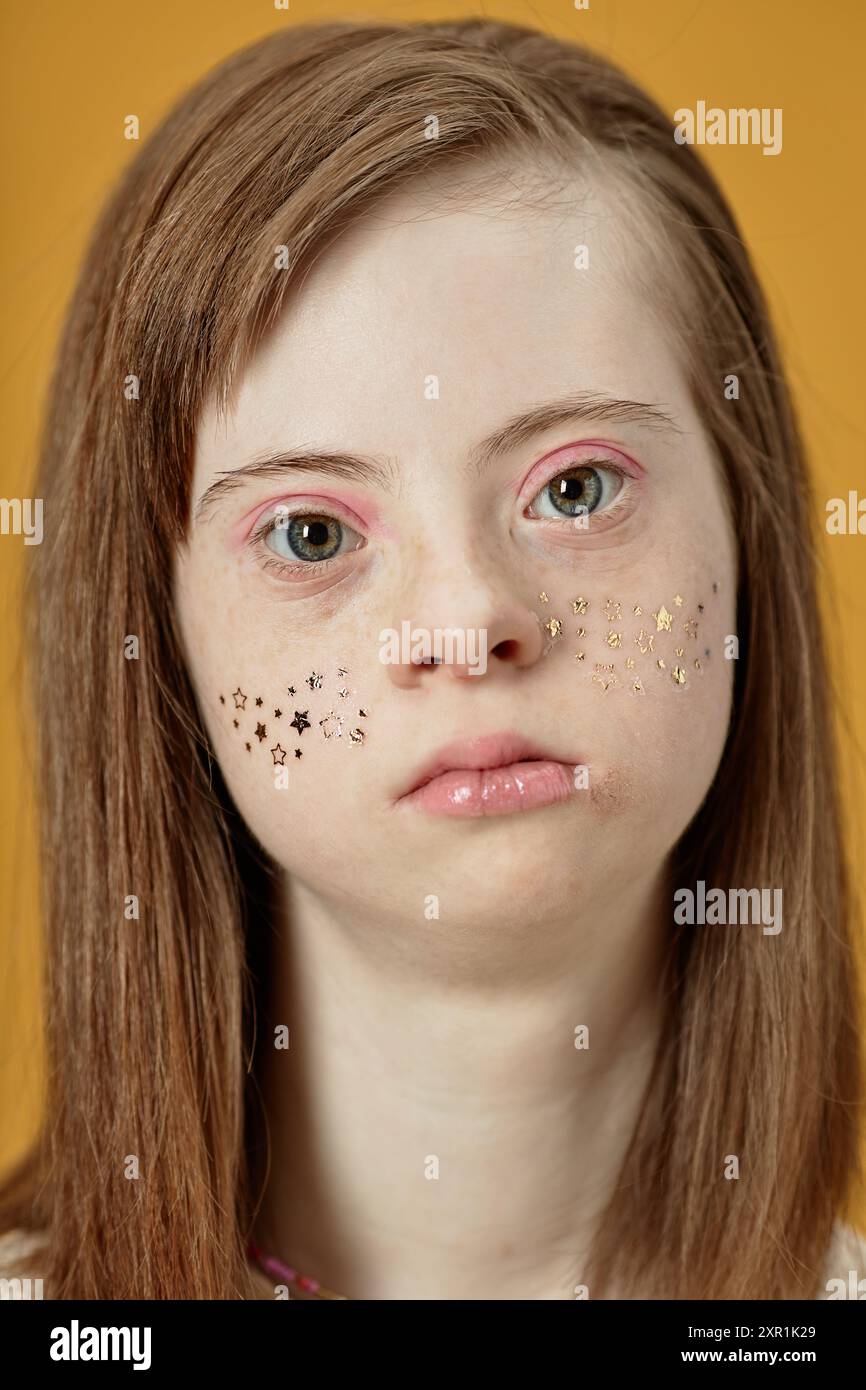 Portrait of girl with Down syndrome looking at camera, featuring 