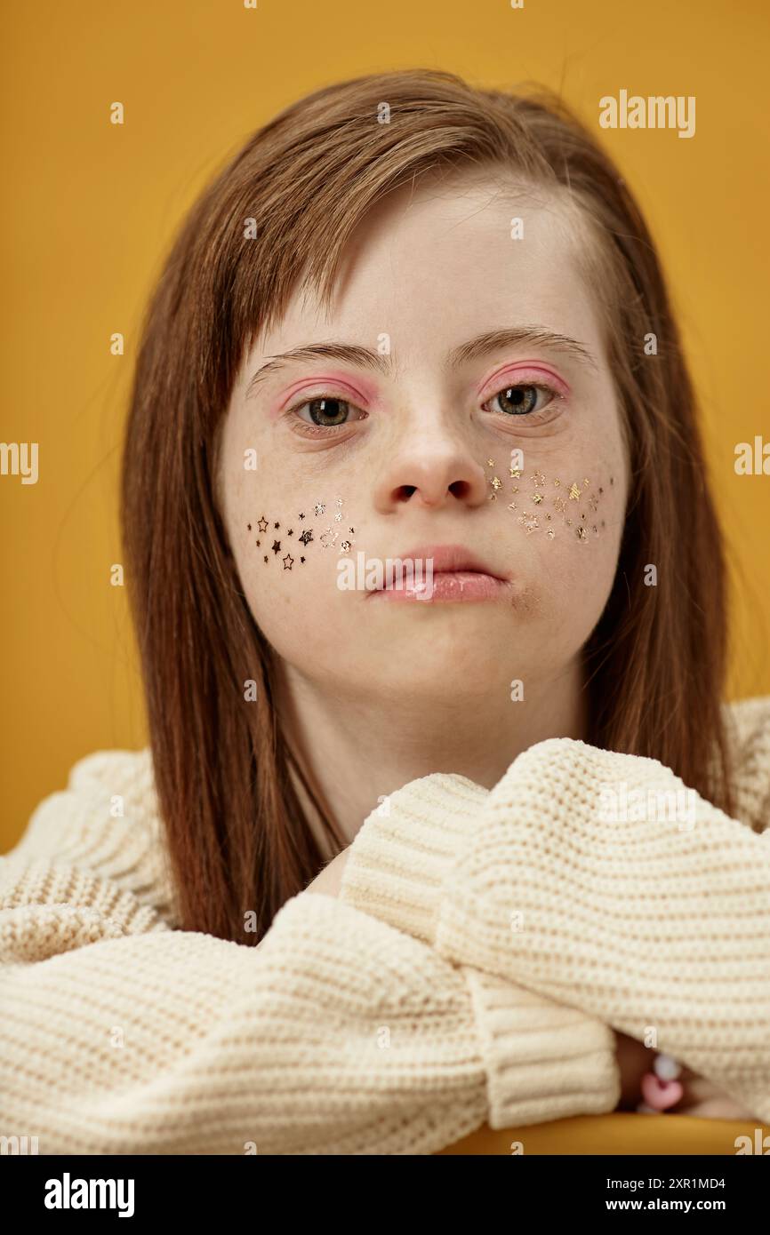 Portrait of young woman with Down syndrome having glitter on her cheeks ...