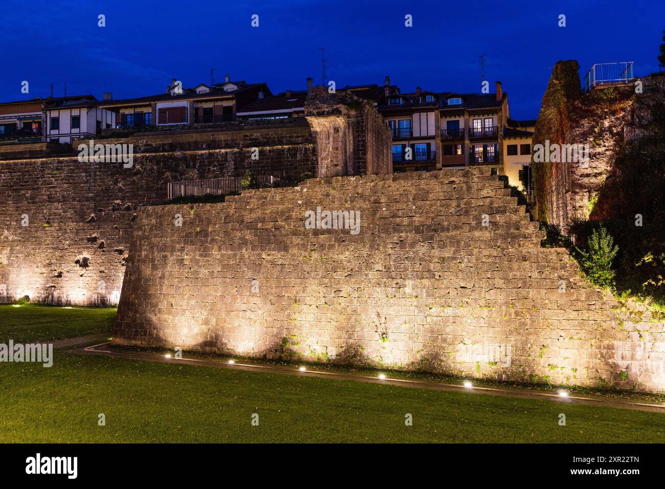 Old medieval city stone fortress wall illuminated by spotlights. Evening. Hondarribia, Basque Country, Spain. Stock Photo