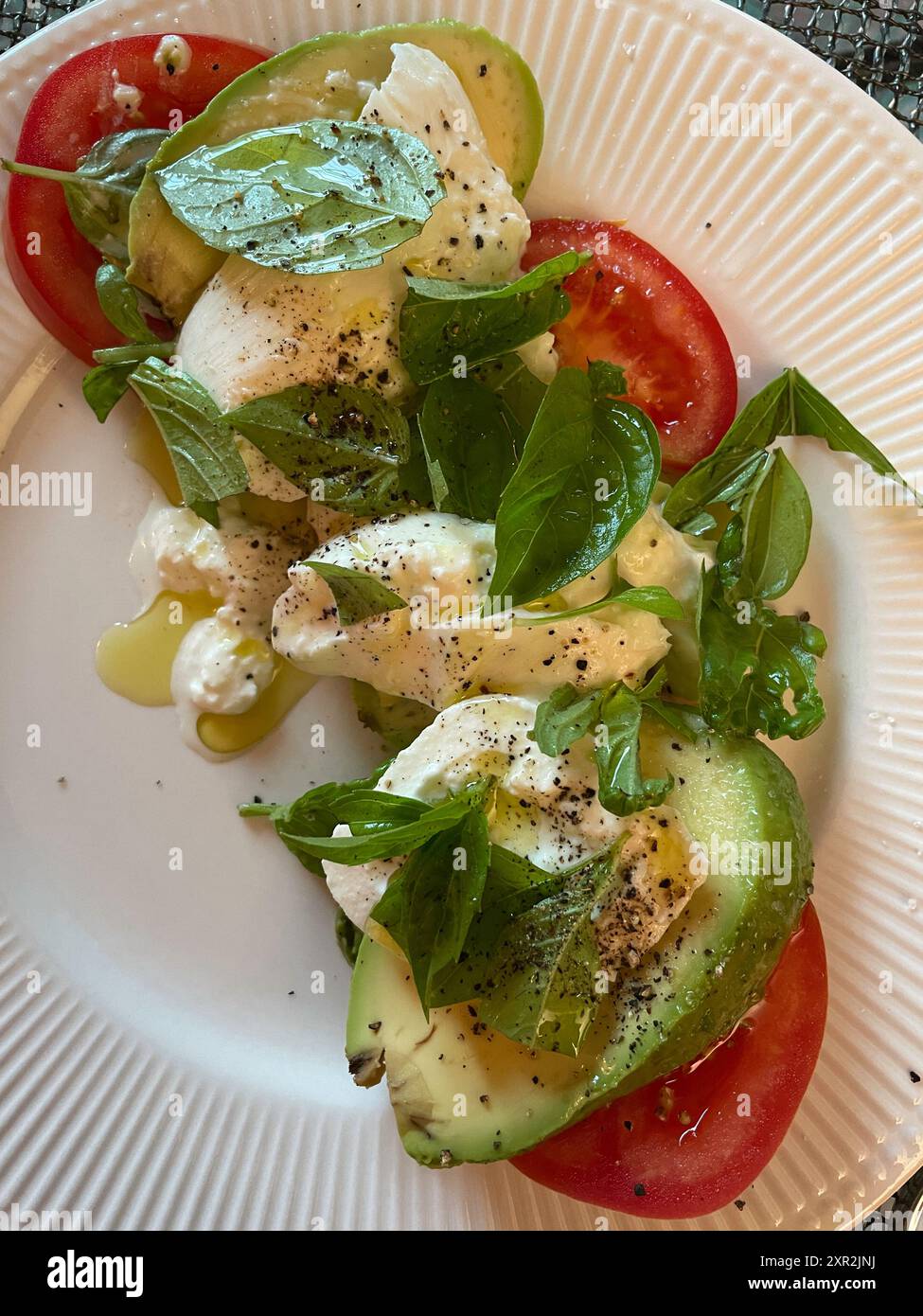 Close-up of a avocado, tomato, basil, and burrata cheese salad, 2024, USA Stock Photo