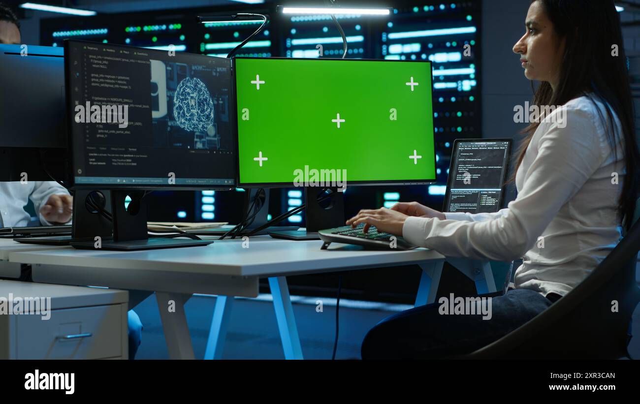 Technician doing checkup on green screen server hub PC to optimize it for data processing requirements of AI. Worker inspects data center used for machine learning using mockup computer, camera A Stock Photo