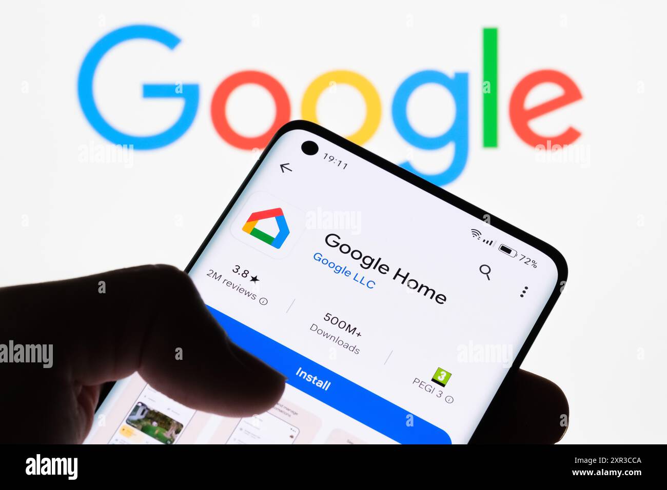 Close-up of a smartphone screen displaying Google Home app with Google logo in the background, highlighting the connection between Google Home and Goo Stock Photo