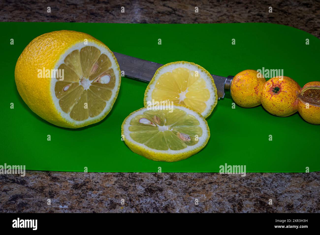 Fresh juicy sliced lemon on a green cutting board. on the kitchen counter Stock Photo