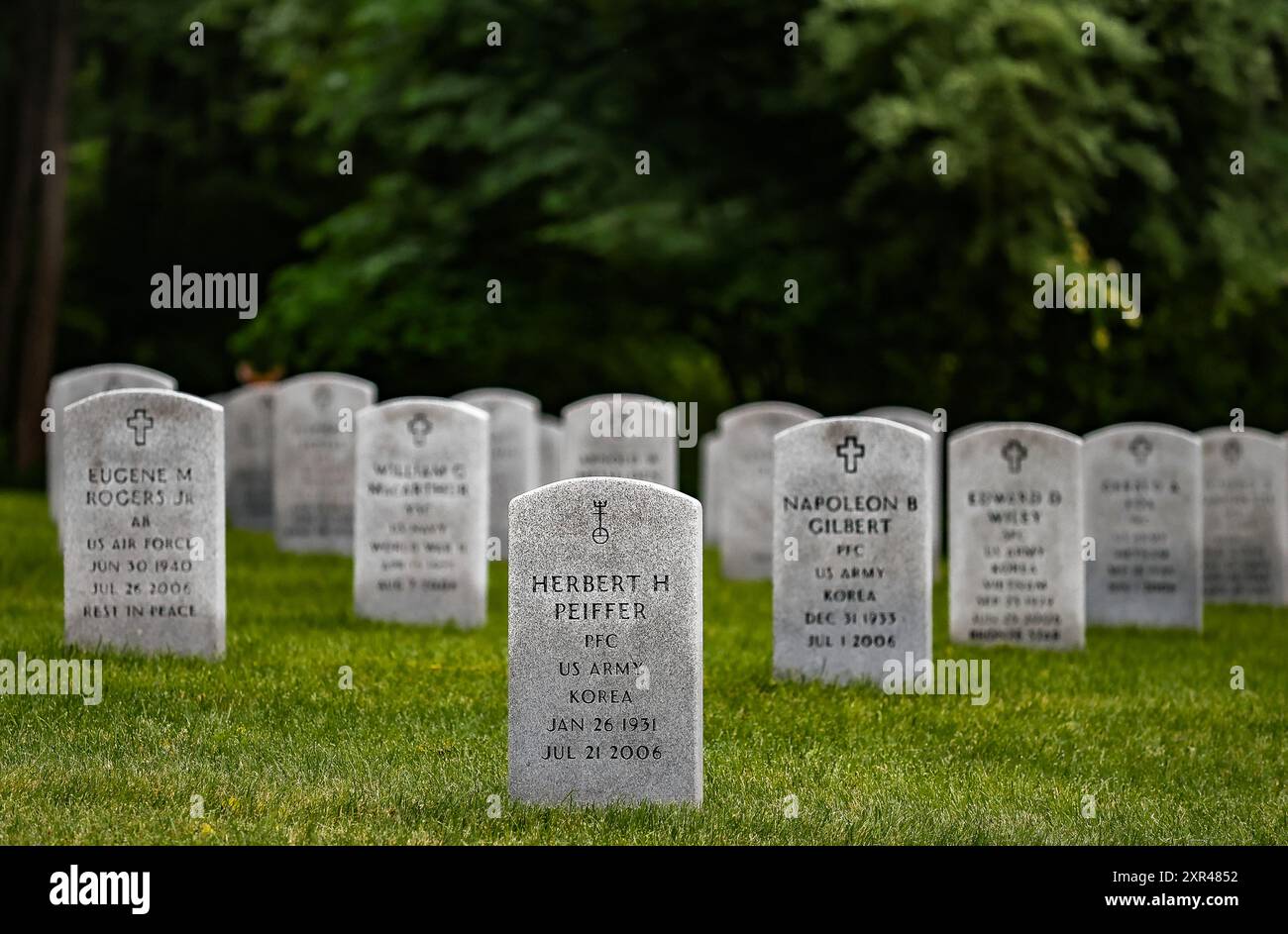 A solemn tribute: Rows of white headstones in a military cemetery, honoring the brave men and women who served their country. Stock Photo