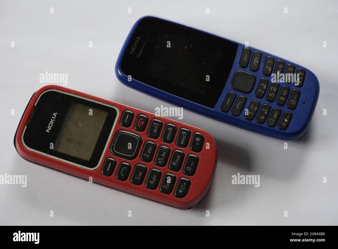 Terengganu, Malaysia - 24 August 2024 : Closeup of two nokia keypad phones on isolated background. Blue and red colors. Stock Photo