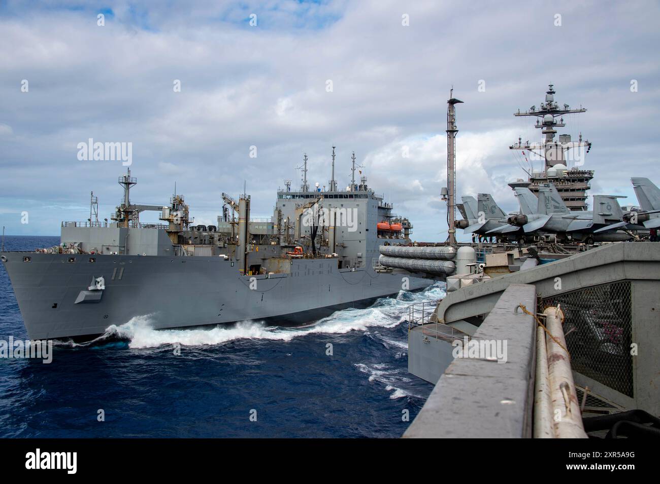 Nimitz-class aircraft carrier USS Carl Vinson (CVN 70) conducts a replenishment-at-sea with Lewis and Clark-class dry cargo ship USNS Washington Chambers (T-AKE 11) during RIMPAC 2024. Twenty-nine nations, 40 surface ships, three submarines, 14 national land forces, more than 150 aircraft and 25,000 personnel are participating in RIMPAC in and around the Hawaiian Islands, June 27 to Aug. 1. The world’s largest international maritime exercise, RIMPAC provides a unique training opportunity while fostering and sustaining cooperative relationships among participants critical to ensuring the safety Stock Photo