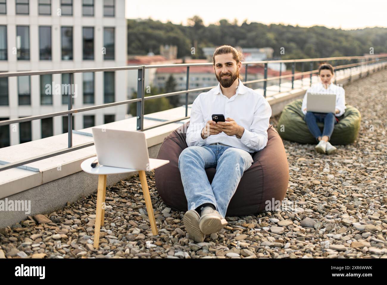 Two professionals working remotely on modern rooftop Stock Photo