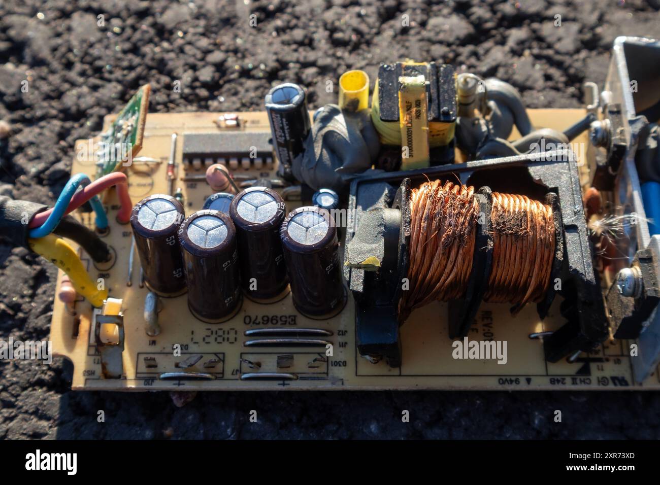 broken electronics board on asphalt outdoors in sunlight Stock Photo