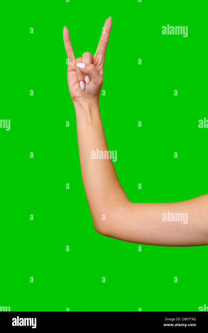 Closeup of Woman's Hand Making the Rock and Roll Sign Against a Green ...