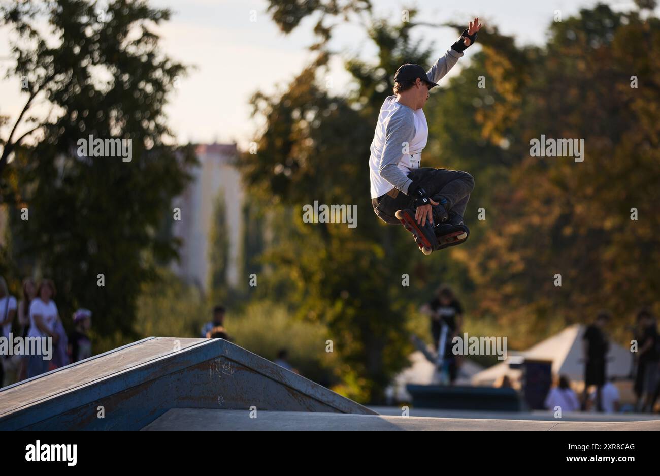 Inline skater performing 540 safety grab trick in a skatepark. Inline
