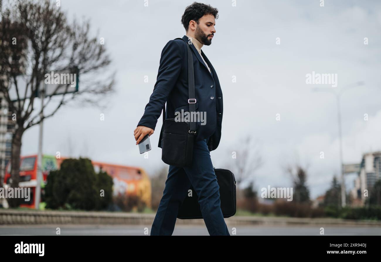 Confident businessman walking across the street in the city Stock Photo ...